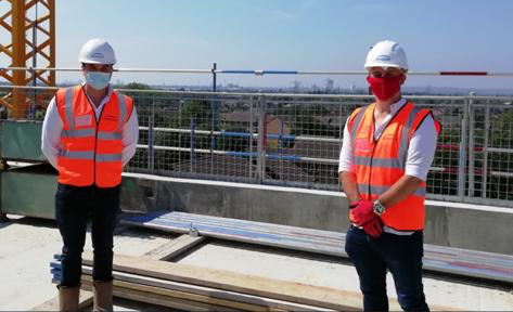 Two men in hard hats on building site